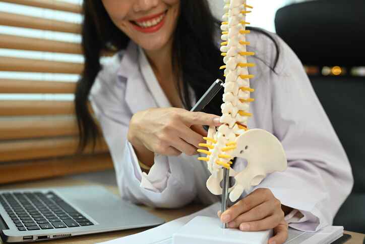 Doctor explaining spinal structure as part of regenerative wellness services in Lansing designed to support joint and tissue healing.
